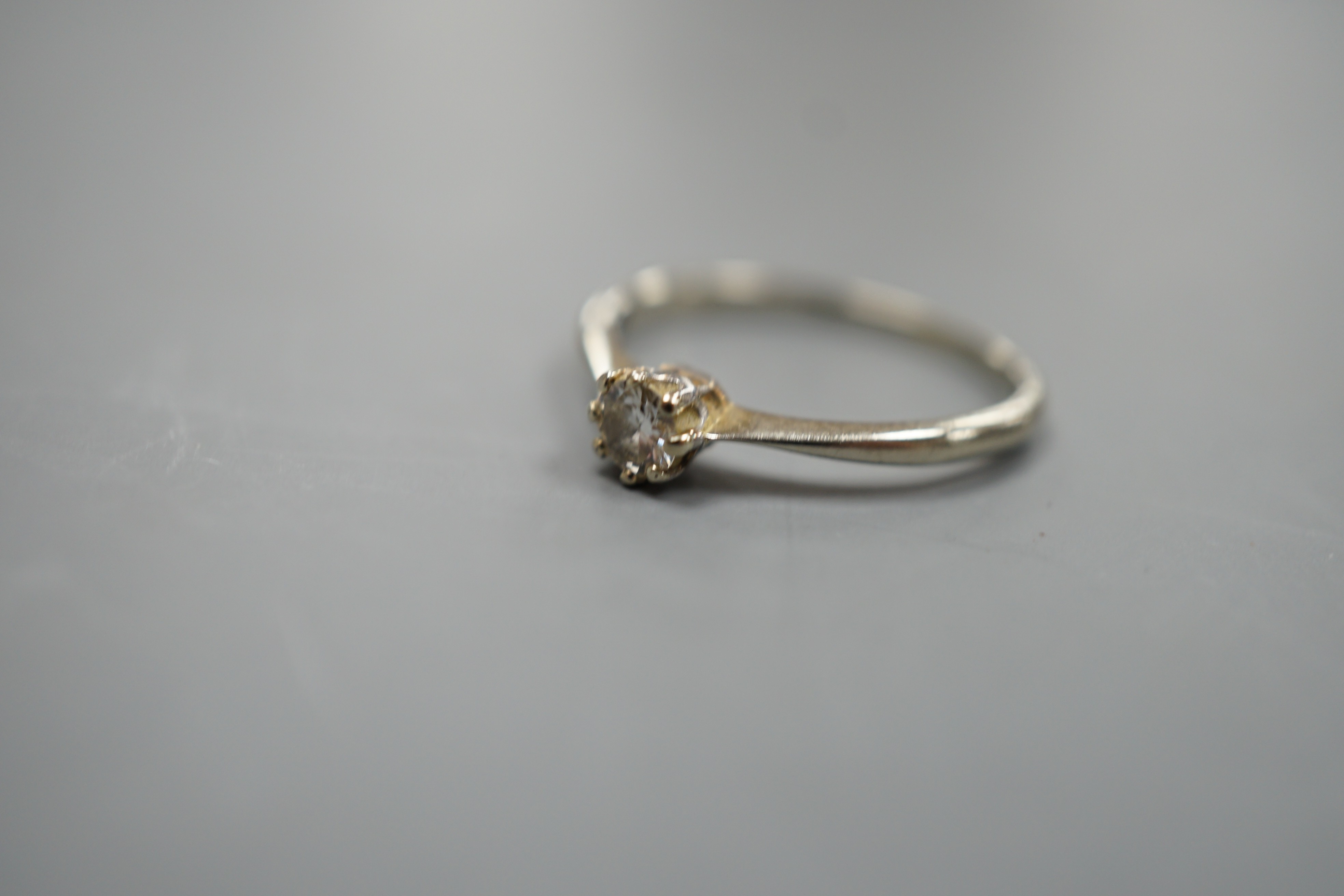 An 18ct and plat, solitaire diamond ring, size M, gross weight 1.7 grams.